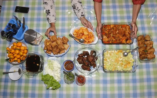 Members of Yoni Budiharjo's family set food on a table for Iftar before they break their fast together at their house during Ramadan in Depok, Indonesia, 23 March 2023. Iftar is the fast-breaking meal eaten by Muslims during the fasting month of Ramadan immediately after sunset. Muslims around the world celebrate Ramadan by praying during the night time and abstaining from eating, drinking, and sexual acts during the period between sunrise and sunset. Ramadan is the ninth month in the Islamic calendar and it is believed that the revelation of the first verse in the Koran was during its last 10 nights. (Photo by Adi Weda/EPA/EFE)