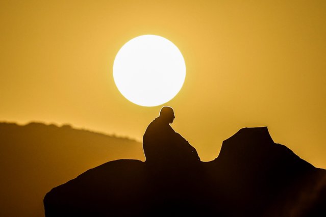 A Muslim pilgrim prays at dawn on Mount Arafat, also known as Jabal al-Rahma or Mount of Mercy, during the annual hajj pilgrimage on June 15, 2024. Friends and family searched for missing hajj pilgrims on June 19 as the death toll at the annual rituals, which were carried out in scorching heat, surged past 900. (Photo by Fadel Senna/AFP Photo)