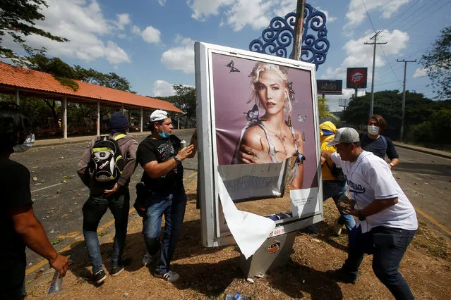 Demonstrators destroy an advertising sign during a protest over a controversial reform to the pension plans of the Nicaraguan Social Security Institute (INSS) in Managua, Nicaragua April 20, 2018. (Photo by Jorge Cabrera/Reuters)