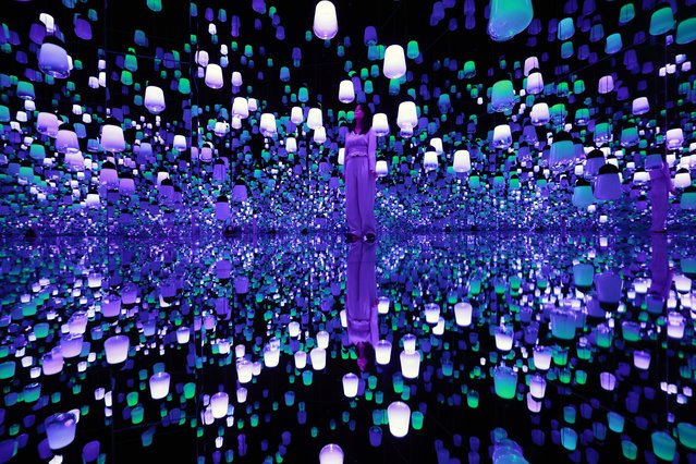 A staff member looks at the artwork Forest of Resonating Lamps: One Stroke – a Year in the Mountains during a preview of the new museum “teamLab Biovortex Kyoto” in Kyoto, western Japan, 24 September 2025. Art collective teamLab will open to the public its new permanent art museum, teamLab Biovortex Kyoto, on 07 October 2025. The facility will be teamLab's largest museum in Japan, featuring more than 50 artworks. (Photo by Franck Robichon/EPA)