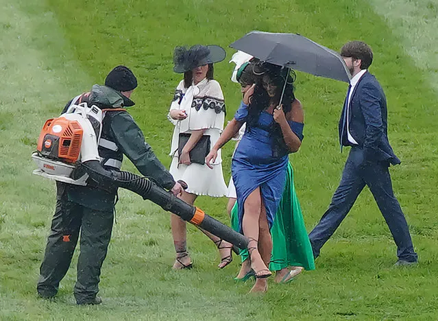 A racegoer has groundstaff dry a foot with a leaf-blower during day two of the Randox Grand National Festival at Aintree Racecourse, Liverpool on Friday, April 14, 2023. (Photo by Peter Byrne/PA Images via Getty Images)