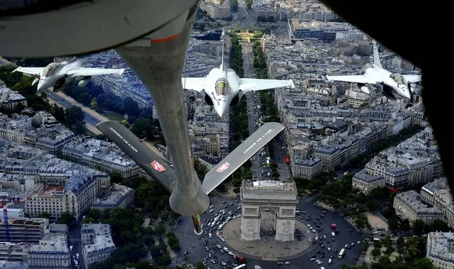 Seen from a refuelling plane, French Rafale jet fighters fly above the Arc of Triumph on a training mission over Paris, in preparation for the Bastille Day military parade. (Photo by Boris Horvat/AFP/Getty Images)