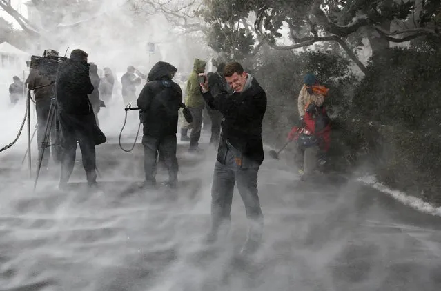 Members of the press, including NBC's Evan Dixon, face the blowing snow caused by Marine One as it landed on the South Lawn before picking up U.S. President Barack Obama at the White House in Washington, January 7, 2015. Obama is departing for a two-day trip to Michigan and Arizona. (Photo by Larry Downing/Reuters)