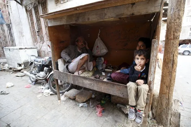 A man and his sons sit inside a kiosk at the old quarter of Yemen's capital Sanaa November 27, 2015. (Photo by Khaled Abdullah/Reuters)
