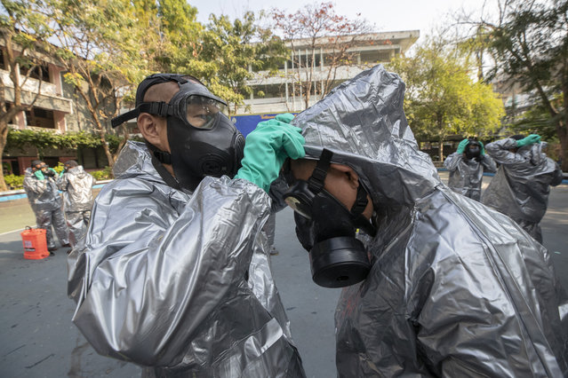 Soldiers from Royal Thai Army Chemical Department prepare to spray disinfectant as a precaution against the coronavirus at Bang Bua school in Bangkok, Thailand, Tuesday, January 26, 2021. (Photo by Sakchai Lalit/AP Photo)