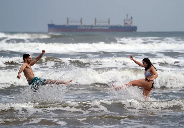 Ollie King, 22, and his sister Laura, 19, take a dip into the sea at King Edward's Bay in Tynemouth, United Kingdom on January 1, 2021. (Photo by Owen Humphreys/PA Images via Getty Images)