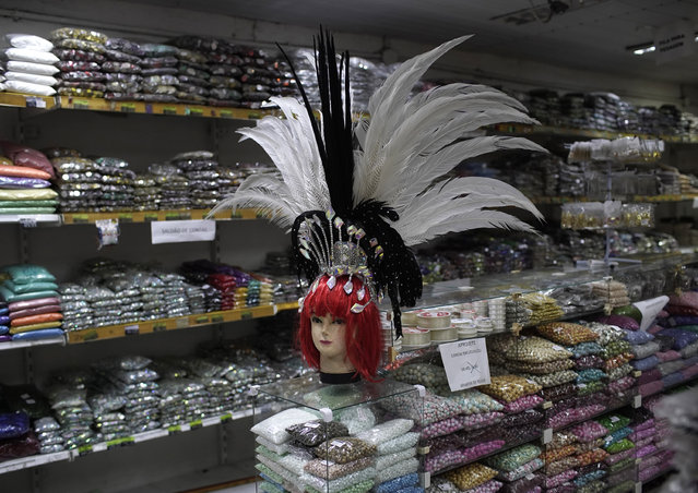 A mannequin head dons a Carnival feather headdress for sale at a costume party store in Rio de Janeiro, Brazil, Thursday, February 4, 2021, amid the COVID-19 pandemic. The cancellation of Carnival celebrations due to the new coronavirus pandemic has created a deep economic hole for many businesses dependent on the massive crowds attracted to the annual street party. (Photo by Silvia Izquierdo/AP Photo)