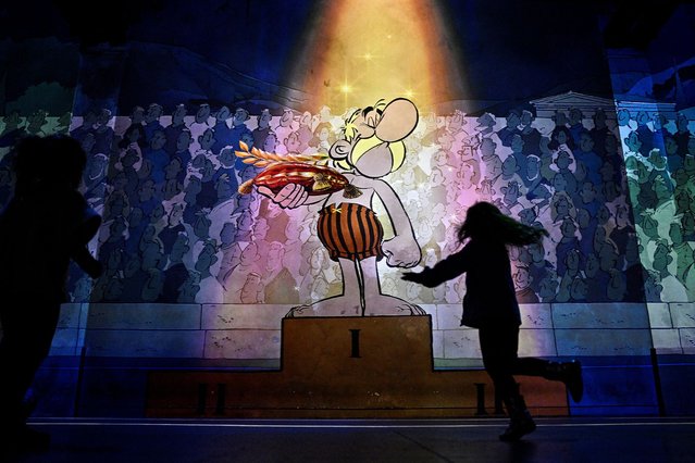 A visitor look at the light installations at the Atelier des Lumieres, during a press preview of the exhibition titled “Asterix the Immersive Voyage”, based on the French comic album series, in Paris on October 17, 2024. The exhibition will be open from Octobre 18, 2024 – January 5, 2025. (Photo by Julien de Rosa/AFP Photo)