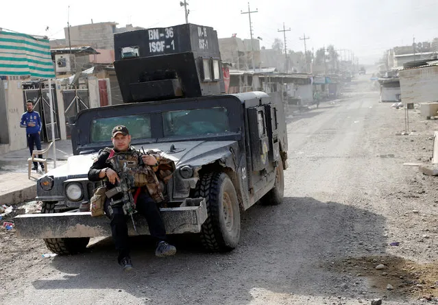 An Iraqi special forces soldier takes a ride sitting in front of a vehicle in Mosul, Iraq November 14, 2016. (Photo by Goran Tomasevic/Reuters)