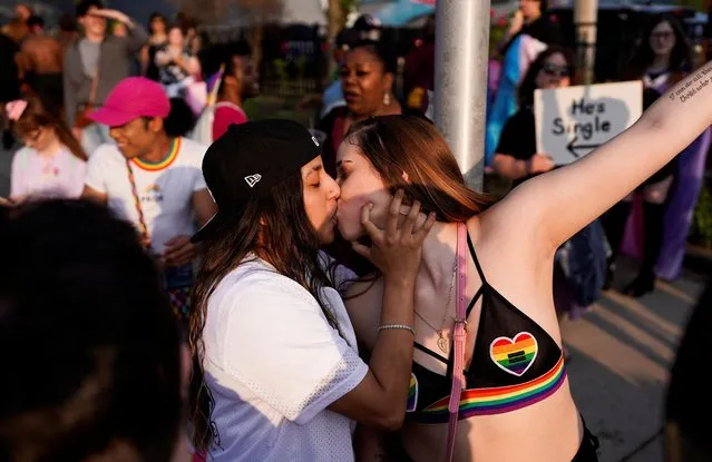 Revelers kiss while Christians preach during a Pride rally in Lansing, Michigan, U.S., June 17, 2023. (Photo by Dieu-Nalio Chery/Reuters)