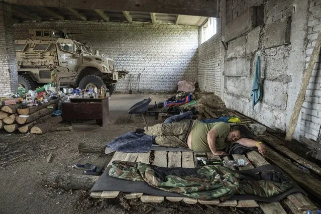 A Ukrainian serviceman of the 68th Oleksa Dovbush hunting brigade rests after night duty in Donetsk region, Ukraine, Saturday, June 17, 2023. (Photo by Evgeniy Maloletka/AP Photo)