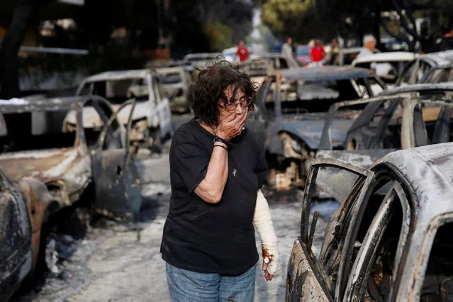 A woman reacts as she tries to find her dog, following a wildfire at the village of Mati, near Athens, Greece July 24, 2018. (Photo by Costas Baltas/Reuters)