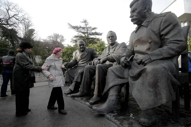 Women stand next to the sculptures of (R-L) Soviet dictator Josef Stalin, U.S. President Franklin Roosevelt and British Prime Minister Winston Churchill, made by Zurab Tsereteli, during its opening ceremony in the settlement of Livadia, Yalta region, Crimea, February 5, 2015. (Photo by Pavel Rebrov/Reuters)