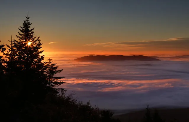 Pleasant Mountain protrudes from a sea of  fog at sunrise Wednesday, October 5, 2016, near Bridgton, Maine. Cool evening temperatures combined with calm, clear weather created ideal conditions for the formation of the valley fog. (Photo by Robert F. Bukaty/AP Photo)