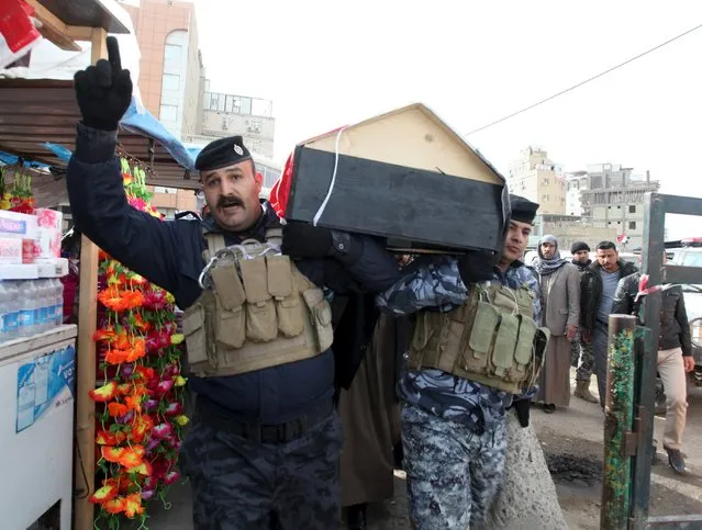 Mourners carry the coffin of a member from the Iraqi security forces, who was killed in the city of Ramadi, during a funeral in Najaf, south of Baghdad, December 27 2015. (Photo by Alaa Al-Marjani/Reuters)