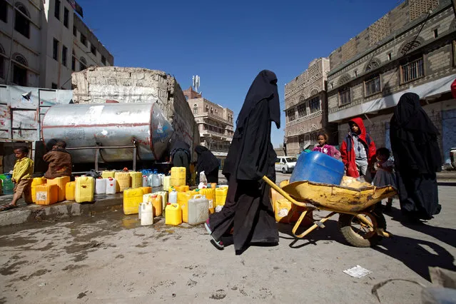 A woman uses a wheelbarrow to carry a jerrycan filled with potable water from a charity tap during the first day of a 48-hour ceasefire in Sanaa, Yemen November 19, 2016. (Photo by Mohamed al-Sayaghi/Reuters)