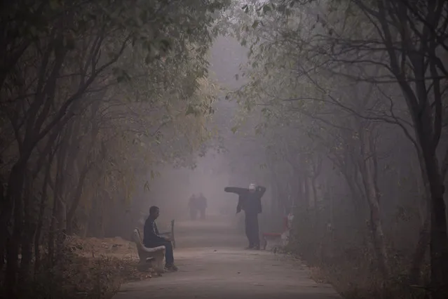 People exercise at a park on a foggy morning in New Delhi, India, Wednesday, December 23, 2015. (Photo by Saurabh Das/AP Photo)