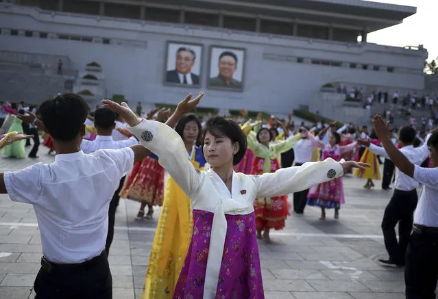 North Koreans take part in a mass dance during the commemoration of the 65th anniversary of the end of the Korean War, which the country celebrates as the day of “victory in the fatherland liberation war”, at Kim Il Sung Square in Pyongyang, North Korea, Friday, July 27, 2018. (Photo by Dita Alangkara/AP Photo)