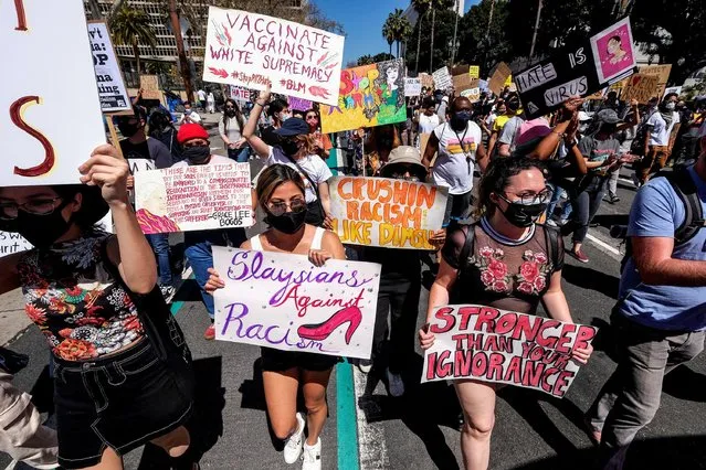 Demonstrators holding signs march during a rally against anti-Asian hate crimes outside City Hall in Los Angeles, California, U.S. March 27, 2021. (Photo by Ringo Chiu/Reuters)