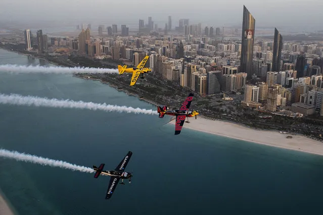 In this Tuesday, February 10, 2015, photo provided by Joerg Mitter via Global-Newsroom, Francois Le Vot of France, from top, U.S. Kirby Chambliss and Pete McLeod of Canada fly over waters off Abu Dhabi, the United Arab Emirates. (Photo by Predrag Vuckovic/AP Photo/Global-Newsroom)