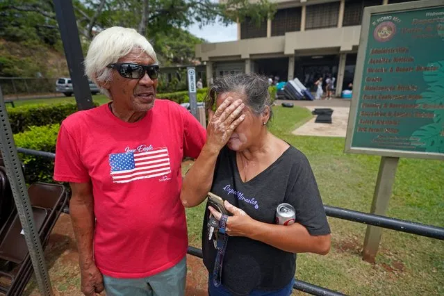 Myrna and Abraham Ah Hee react as they stand in front of an evacuation center at the War Memorial Gymnasium, Thursday, August 10, 2023, in Wailuku, Hawaii. The Ah Hees were there because they were looking for Abraham's brother. Their own home in Lahaina was spared, but the homes of many of their relatives were destroyed by wildfires. They haven't been able to get in touch with Abraham's brother. (Photo by Rick Bowmer/AP Photo)
