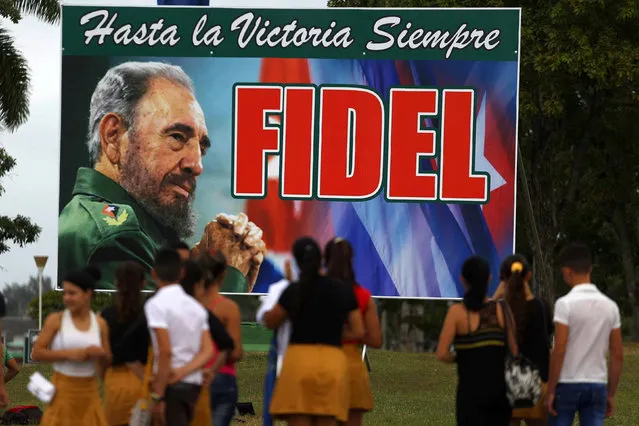People stand in front of a billboard to Cuba's late President Fidel Castro in Santa Clara, Cuba, November 30, 2016. (Photo by Ivan Alvarado/Reuters)