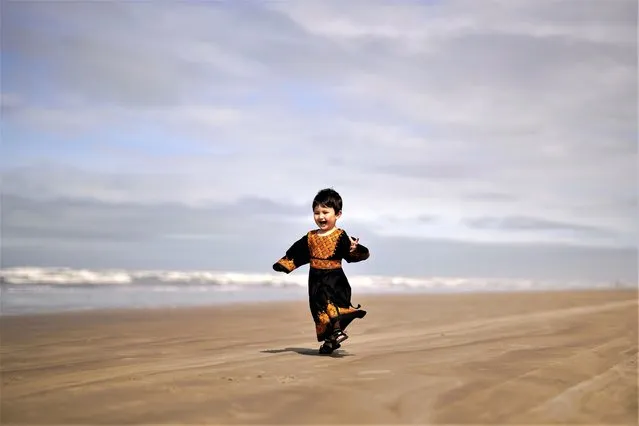 Two-year-old Afghan refugee Farnia Hassani plays on the beach in Praia Grande, Sao Paulo state, Brazil, Tuesday, August 15, 2023. Afghan refugees continue to arrive in Brazil with government-authorized temporary visas and residences issued for humanitarian reasons. (Photo by Andre Penner/AP Photo)