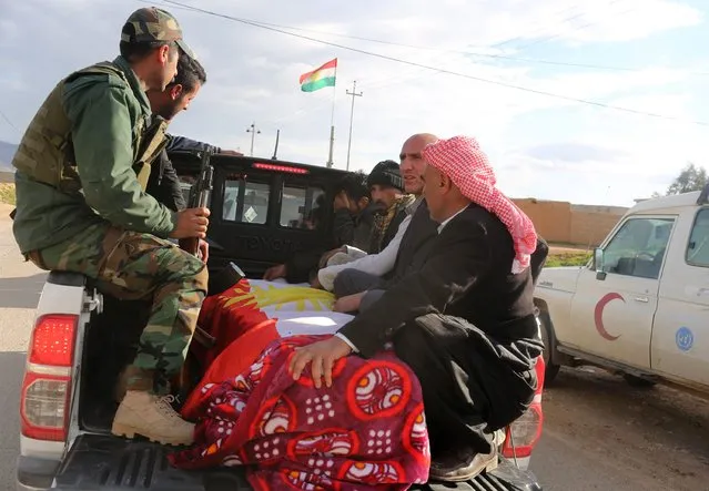 Members of the Peshmerga and relatives of a Peshmerga fighter killed in a suicide attack in Sinjar province, transport the body for a burial ceremony at Mazar Sharaf Eldin, a sacred and cemetery area for the Yazidi minority, north of Sinjar, March 2, 2015.A number of Peshmerga were killed and others injured after two suicide car bombs attacks targeted a building the Peshmerga were using for fighting, according to Peshmerga officials. REUTERS/Asmaa Waguih 