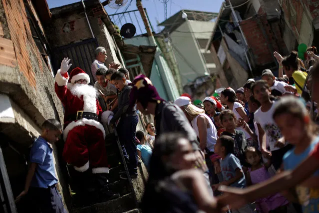 Santa Claus waves during a visit to residents of the slum of Petare in Caracas, Venezuela, December 11, 2016. (Photo by Ueslei Marcelino/Reuters)