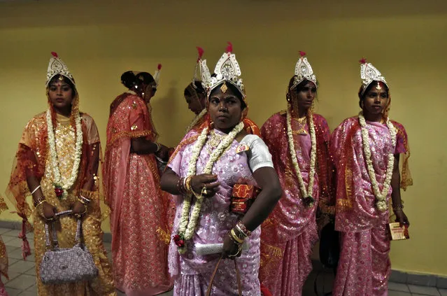 Brides stand outside a toilet as they wait for their grooms at the venue for a mass marriage ceremony in Kolkata June 18, 2014. (Photo by Rupak De Chowdhuri/Reuters)