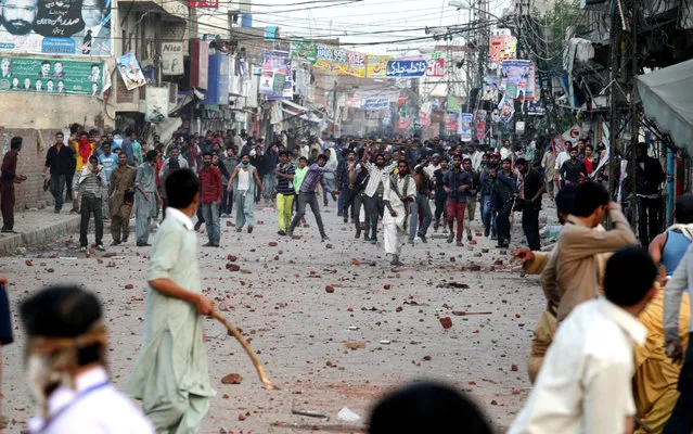Pakistani protesters throw rocks during clashes with police to condemn Sunday's suicide bombings that struck two churches, in Lahore, Pakistan, Monday, March 16, 2015. Pakistani police fired tear gas on Monday after Christian protesters clashed with police in the eastern city of Lahore, a day after Taliban bombers killed more than a dozen people in suicide attacks on two churches in the city. (Photo by K. M. Chaudary/AP Photo)