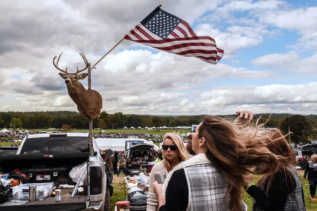 Two women stand near a deer head and the American flag during the 98th running of the Far Hills Race Meeting at Mooreland Farm in Far Hills, New Jersey on October 22, 2018. (Photo by Stephanie Keith/Reuters)