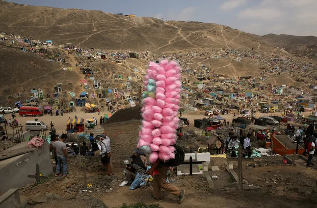 PERU: Street vendor sells candy floss as people visit tombs of relatives and friends at 'Nueva Esperanza' (New Hope) cemetery during the Day of the Dead celebrations in Villa Maria del Triunfo on the outskirts of Lima, Peru, November 1, 2016. (Photo by Mariana Bazo/Reuters)