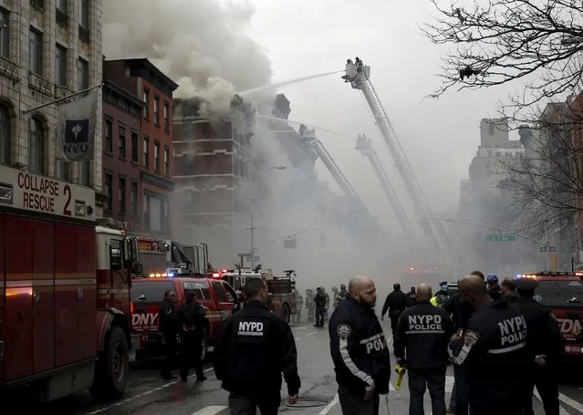 New York City Fire Department firefighters and police stand by as firefighters fight a fire at a residential apartment building in New York City March 26, 2015. (Photo by Mike Segar/Reuters)