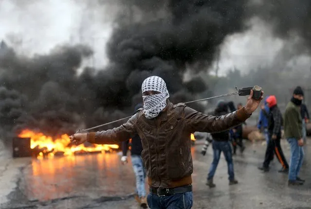A Palestinian protester prepares his sling to hurl stones towards Israeli troops during clashes in the West Bank town of Qabatya, near Jenin February 6, 2016. On Wednesday, three young Palestinian men from Qabatya wielding guns, knives and pipe-bombs killed a paramilitary Israeli policewoman in Jerusalem and were shot dead. In response, Israeli forces raided the assailants' hometown, arresting five suspected militants and imposing a closure. (Photo by Mohamad Torokman/Reuters)