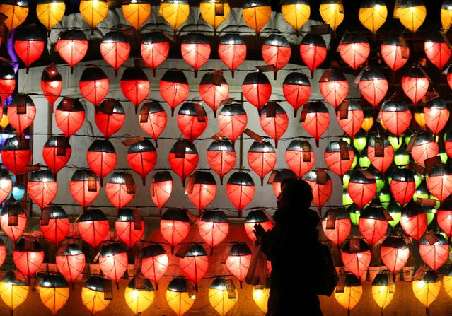 A woman prays in front of lanterns to celebrate the new year at Chogye Buddhist temple in Seoul, South Korea, Saturday, December 31, 2016. (Photo by Ahn Young-joon/AP Photo)