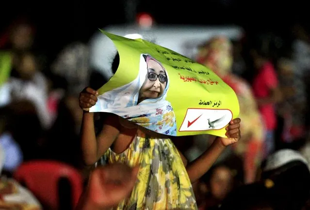 A supporter holds posters of leader of the Sudanese Socialist Democratic Union and presidential candidate Fatima Abdel Mahmoud during her election campaign ahead of the 2015 election, in Khartoum March 31, 2015. (Photo by Mohamed Nureldin Abdallah/Reuters)