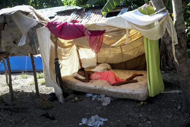 A woman sleeps outside her home in Saint-Louis-du-Sud, Haiti, Monday, August 16, 2021, two days after a 7.2-magnitude earthquake struck the southwestern part of the country. (Photo by Matias Delacroix/AP Photo)