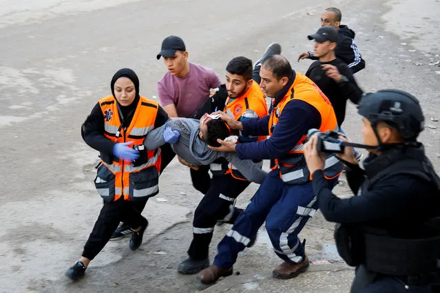 Medics carry an injured person during an Israeli military raid in Jenin, amid the ongoing conflict between Israel and the Palestinian Islamist group Hamas, in the Israeli-occupied West Bank on December 12, 2023. (Photo by Raneen Sawafta/Reuters)