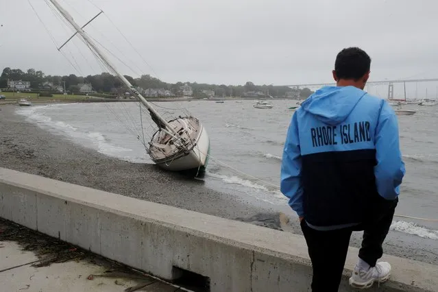 A man looks at a sailboat that came loose from its moorings and was washed ashore during Tropical Storm Henri in Jamestown, Rhode Island, U.S., August 22, 2021. (Photo by Brian Snyder/Reuters)