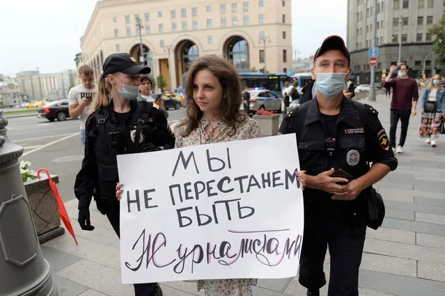 Police detain a journalist with a poster that reads: “We will not stop being journalists” in Moscow, Russia, Saturday, August 21, 2021. (Photo by Denis Kaminev/AP Photo)