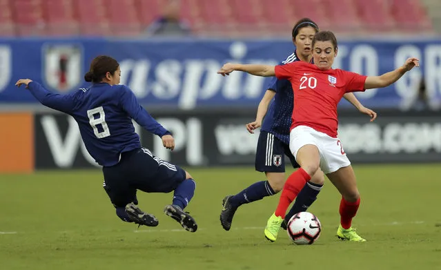 England's Karen Carney (20) tries to avoid the tackle of Japan's Moena Sakaguchi (8) during the first half of a SheBelieves Cup soccer match Tuesday, March 5, 2019, in Tampa, Fla. (Photo by Mike Carlson/AP Photo)