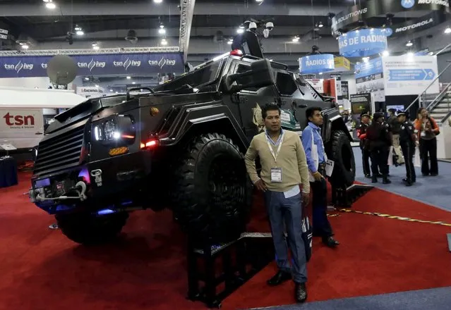 People pose next to a police vehicle during the Expo Seguridad Mexico 2015 security fair in Mexico City April 29, 2015.The exhibition, which runs until April 30, presents the latest in police, civil defence and security equipment. (Photo by Henry Romero/Reuters)