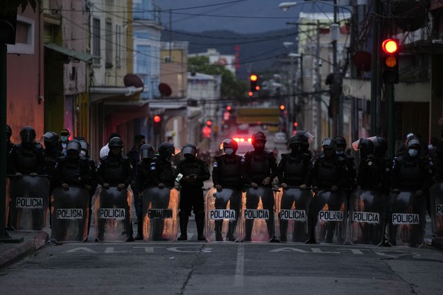 Riot police form a cordon against a group of veterans demanding that a law be passed that compensates them for having served during the country's civil war, outside the Congress building in Guatemala City, Tuesday, October 19, 2021. (Photo by Moises Castillo/AP Photo)
