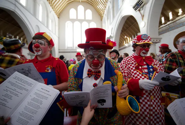 Clowns dressed in full costume attend a Service in memory of celebrated clown Joseph Grimaldi at a church in Dalston, East London on February 2, 2014.  The annual service, attended by clowns, is held in memory of the original “Clown Joey” Joseph Grimaldi, who died in 1837. (Photo by Andrew Cowie/AFP Photo)