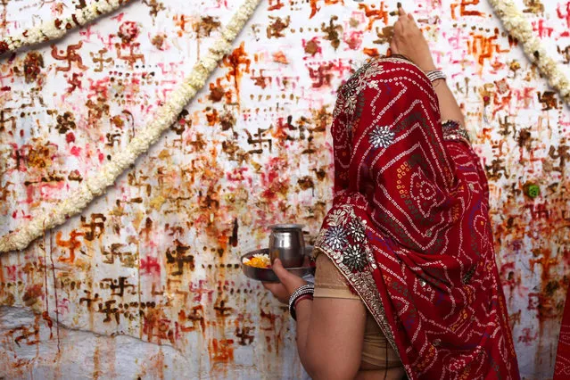 An Indian Hindu woman performs a ritual on the occasion of the “Sheetala Saptami” festival in Ajmer, in the Indian state of Rajasthan on March 27, 2019. The folk deity “Sheetala Mata” is worshipped on the seventh day of the Hindu month Chaitra, where women of the community pray for the well being of their family. (Photo by Himanshu Sharma/AFP Photo)