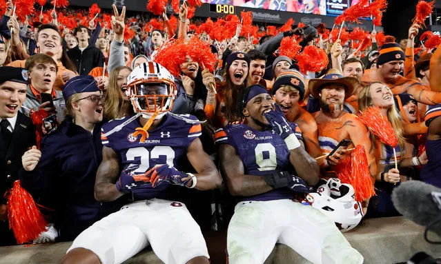 Auburn Tigers cornerback Trey Elston (No 22) and linebacker Zakoby McClain (No 9) celebrate with fans after defeating the Mississippi Rebels at Jordan-Hare Stadium in Auburn, Alabama on October 30, 2021. (Photo by John Reed/Reuter)