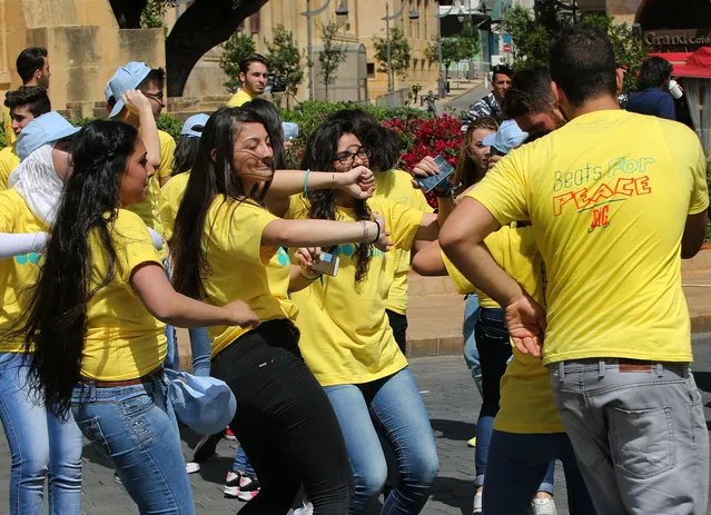 Lebanese students dance during the event The Big Dance “Beats for Peace”, at the Parliament square, in downtown Beirut, Lebanon, Saturday, May 9, 2015. (Photo by Hussein Malla/AP Photo)