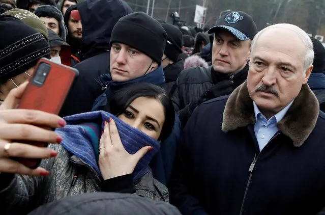 Belarusian President Alexander Lukashenko poses for a selfie as he meets with migrants at the transport and logistics centre Bruzgi on the Belarusian-Polish border, in the Grodno region, Belarus on November 26, 2021. (Photo by Kacper Pempel/Reuters)