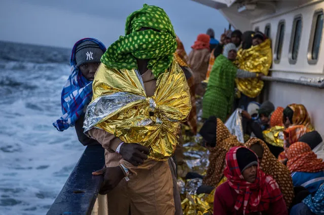 Refugees and migrants are seen on deck of the Spanish NGO Proactiva Open Arms rescue vessel Golfo Azzurro sailing towards the Italian port of Pozzallo after being rescued off Libyan coast north of Sabratha, Libya on February 19, 2017 at Sea. 466 migrants were rescued in high seas last Friday by the Italian Coast Guard and the Spanish NGO Proactiva Open Arms rescue vessel Golfo Azzurro. Proactiva Open Arms are a Spanish charity based out of Malta who provide search and rescue assistance to refugees and migrants in distress at sea. They patrol the SAR and Rescue Zone off the coast of Libya running rescue missions for the hundreds of migrants who continue to make perilous journey across the Mediterranean in hope of reaching the European mainland. (Photo by David Ramos/Getty Images)